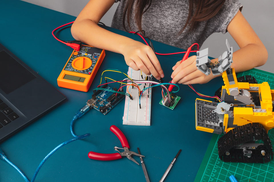 Kid Repairing Something with Wires and Laptop